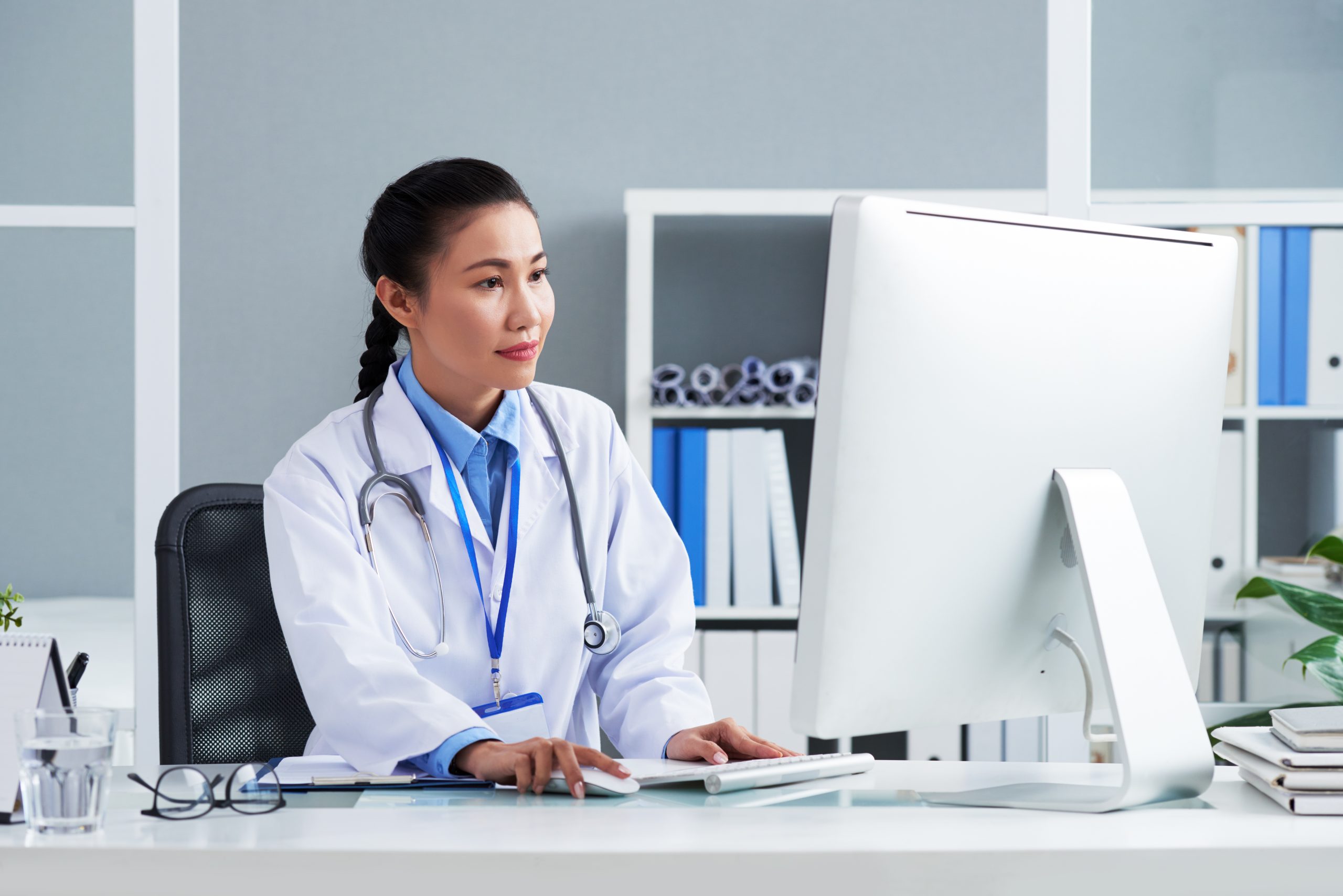 Asian Doctor With Stethoscope Around Neck Sitting Office Working Computer Scaled 1724396733