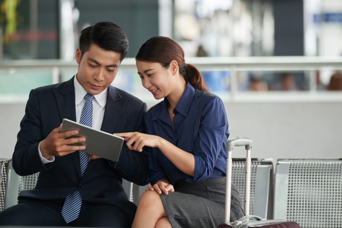 Asian Couple Using Tablet In Airport