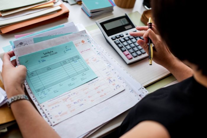 Asian Woman Working Through Paperwork 1750762809